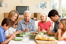 family saying grace before meal